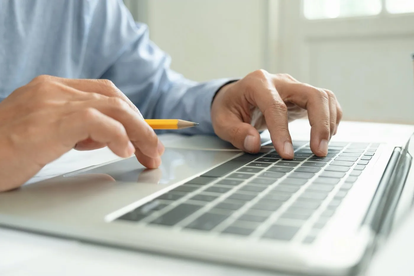 man holding a pencil and keyboard